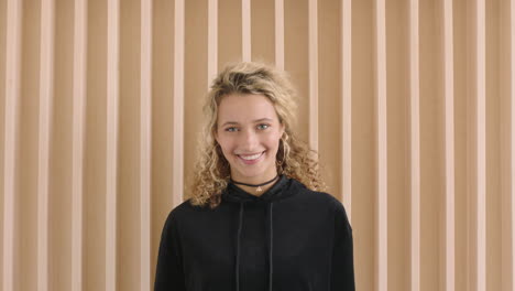 slow-motion-portrait-of-cute-young-blonde-woman-smiling-happy-looking-at-camera-independent-caucasian-female-wearing-black-hoodie