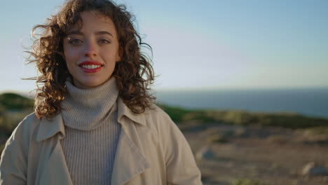 carefree girl walking cliff mountain closeup. romantic woman touching curly hair