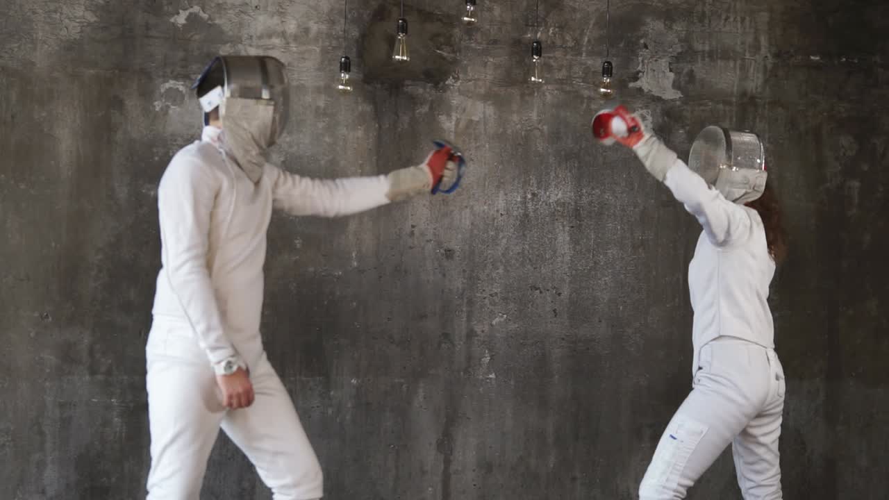 두 명의 펜싱 선수가 행동하고 있습니다.