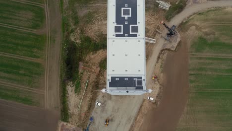 Close-Up-Top-View-Of-A-Huge-White-Wind-Turbine-Turned-off-On-The-Farm---aerial-drone