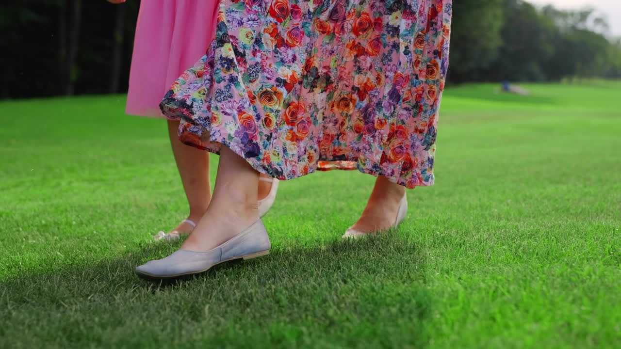 시내 공원에서  ⁇ 고 있는 여성과 소녀의 다리. 가족이 야외에서 시간을 보내고 있습니다.