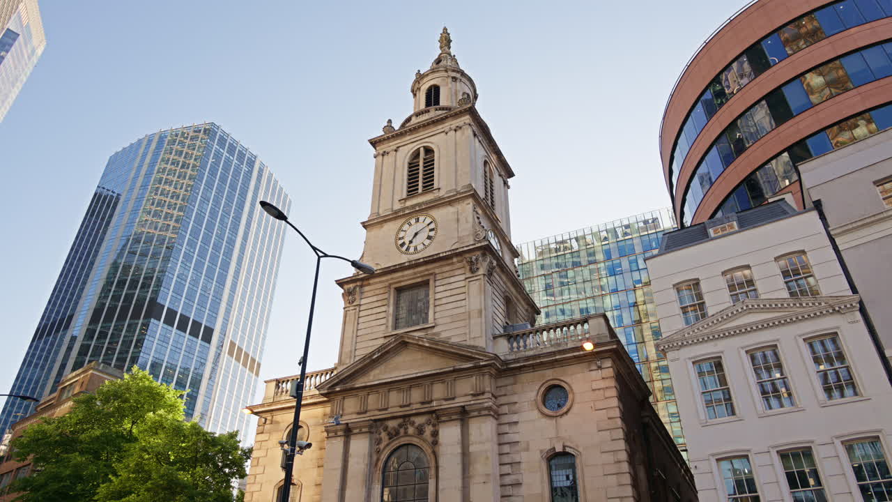St. Botolph-without-Bishopsgate church standing prominently at the edge of Liverpool Street, framed by gleaming glass towers in London, England