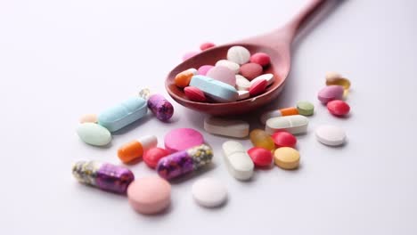 assorted medications in a wooden spoon