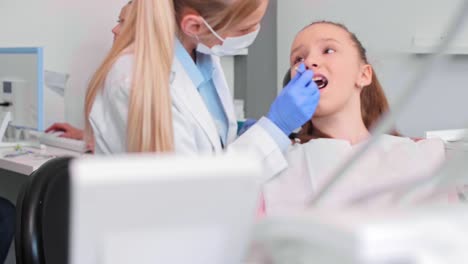 female orthodontist using dental mirror during checkup