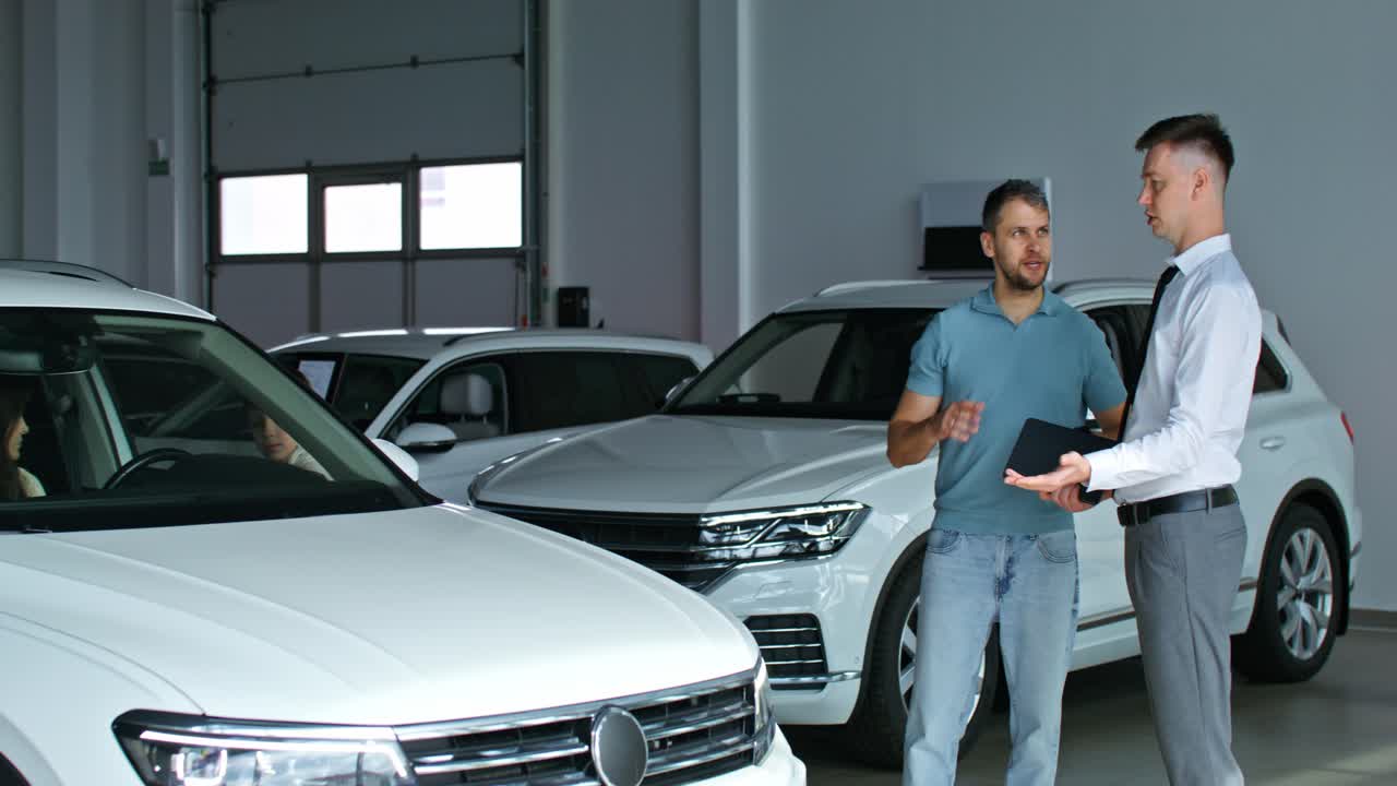 vendedor de automóviles discutiendo el vehículo con el cliente en el concesionario