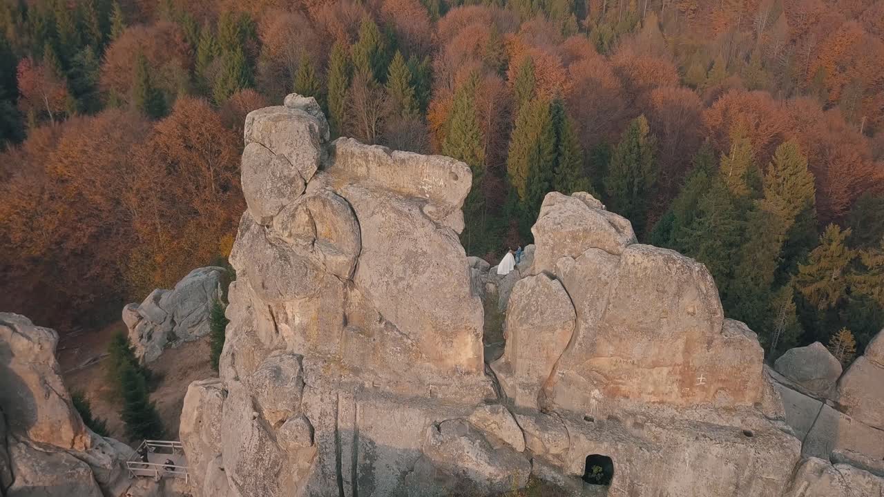 los recién casados están en una ladera alta de la montaña. el novio y la novia.