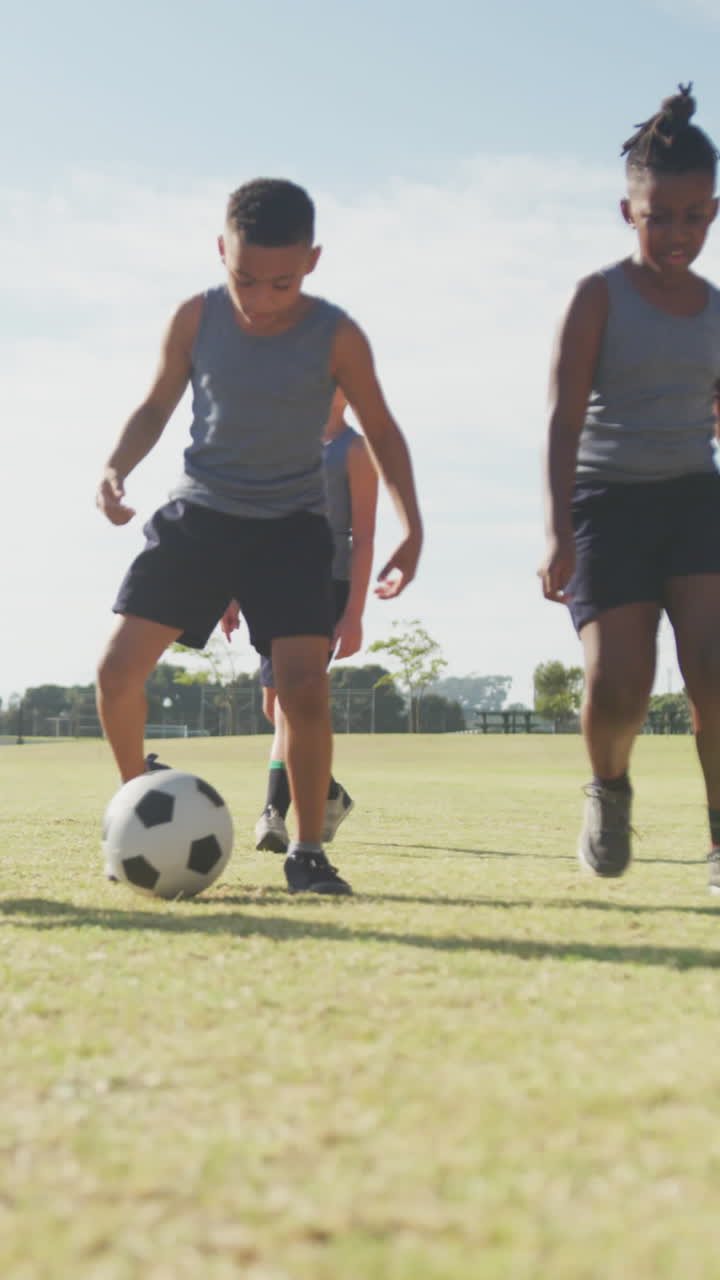 video de niños felices y diversos jugando al fútbol en un campo deportivo