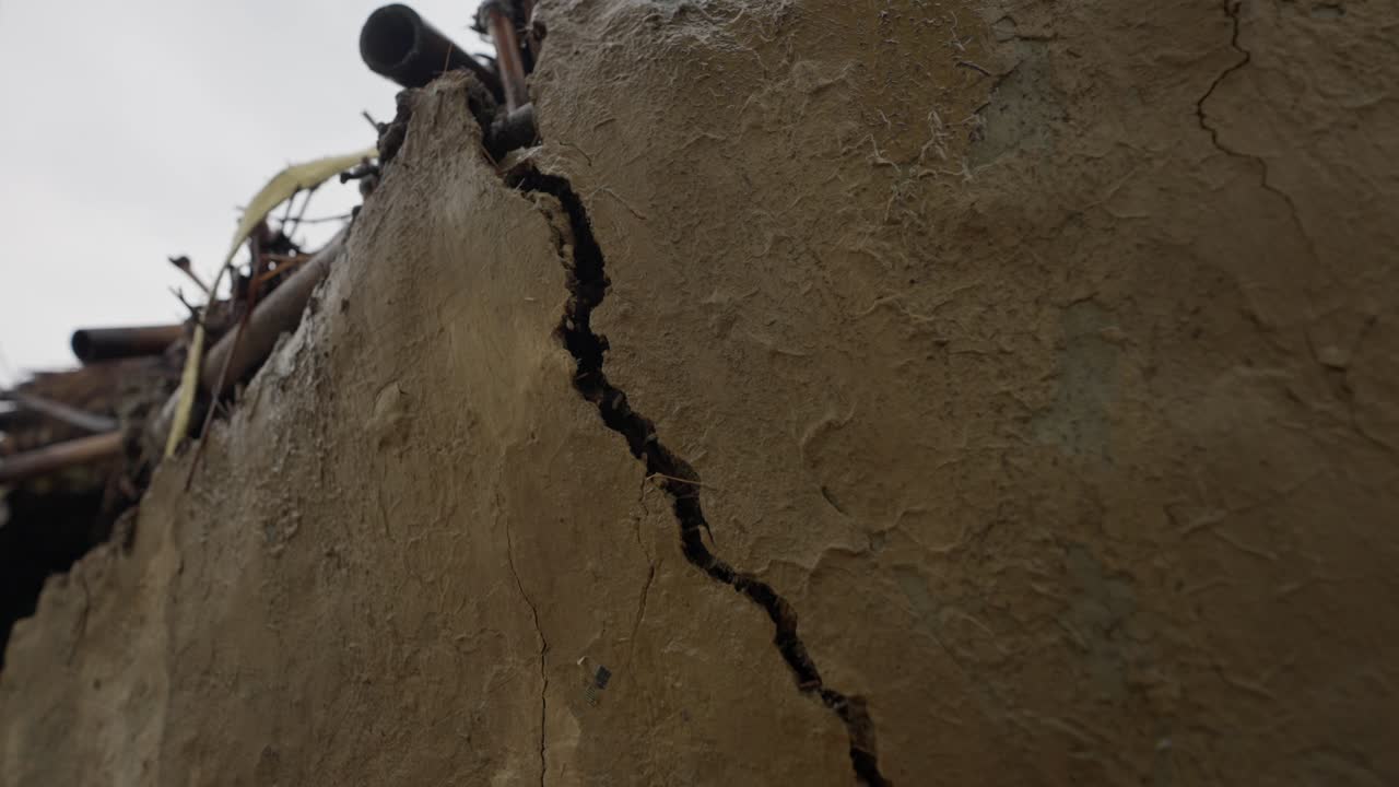 Imágenes de una casa de adobe en un pueblo mostrando una estructura parcialmente derrumbada. Destaca la arquitectura rural, la construcción tradicional y la vida rústica del pueblo.