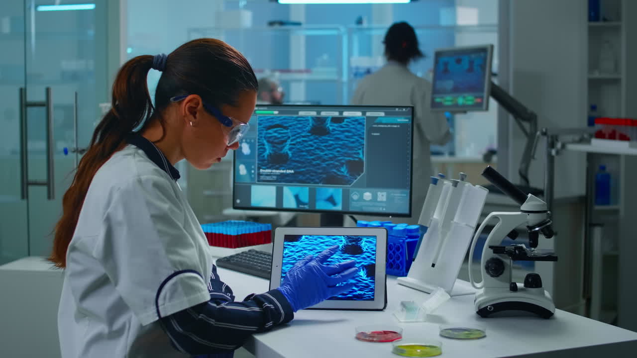 técnico de laboratorio médico analizando la evolución del virus mirando en una tableta digital