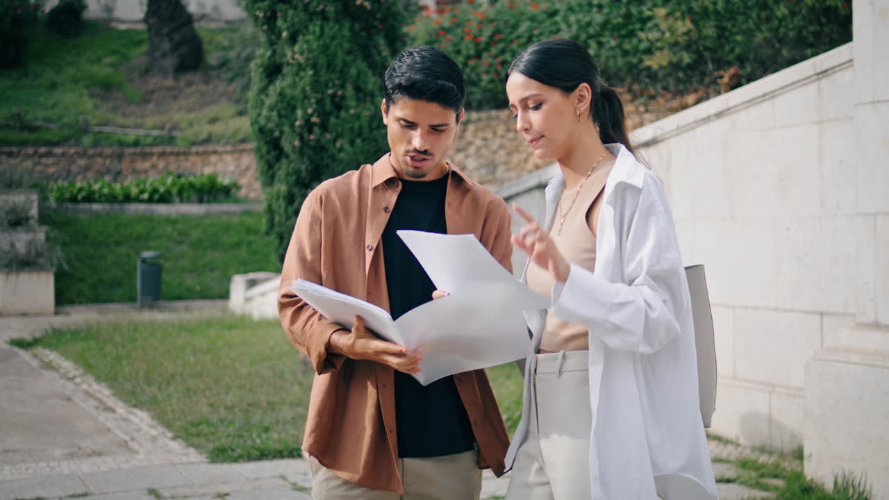 estudiantes inteligentes preparándose para el examen en la plaza. amigos ocupados pareja analizando papeles