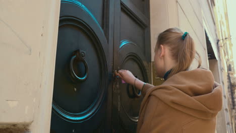 Woman-coming-up-to-house-and-opening-front-door