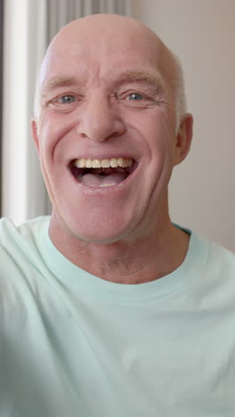 vertical video of portrait of happy senior caucasian man having video call in slow motion