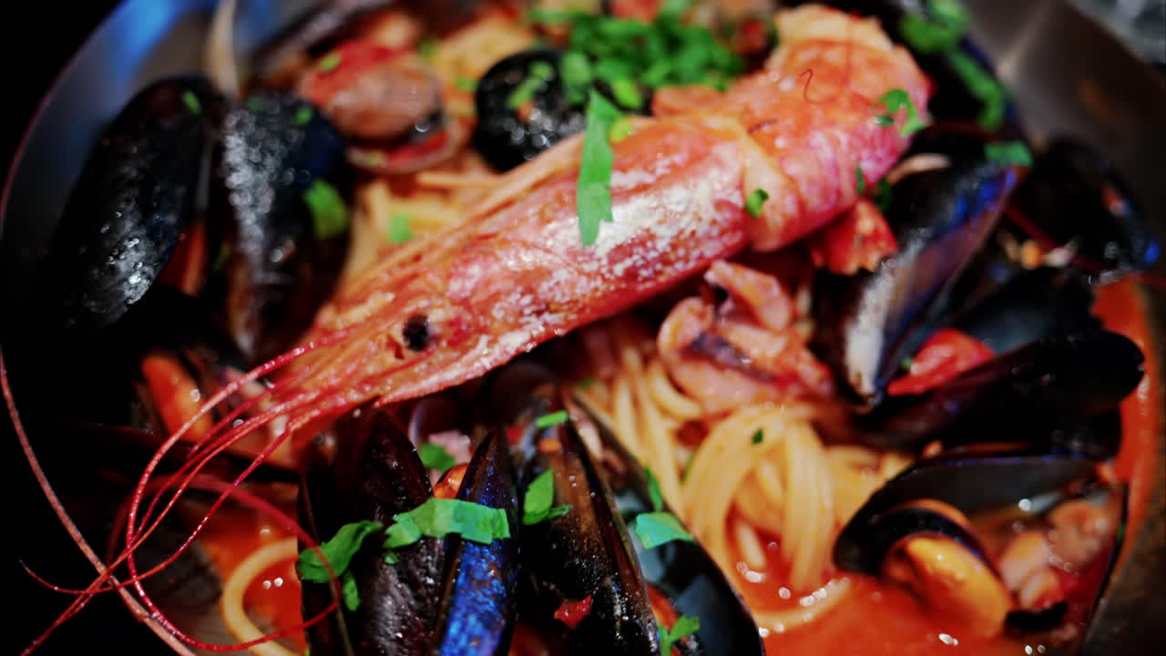 Close up of pasta with tomato sauce and mussels in a pan