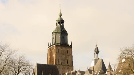 panorámica vertical controlada rápidamente desde la parte superior de la torre walburgiskerk que revela el cuerpo de la catedral y el paisaje nevado de la histórica arquitectura medieval de los edificios de la muralla de la ciudad