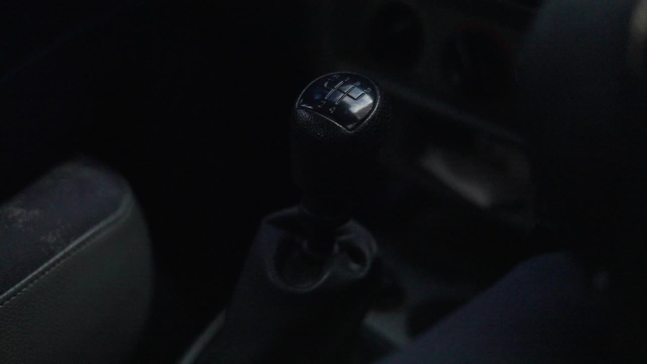 persona cambiando de marcha en un coche