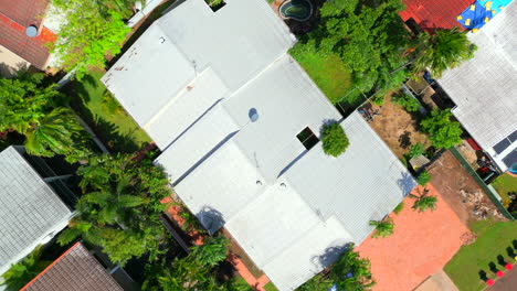 dron aéreo de bloque de unidades de arriba hacia abajo asciende por encima del techo ondulado y el camino de entrada bronceado