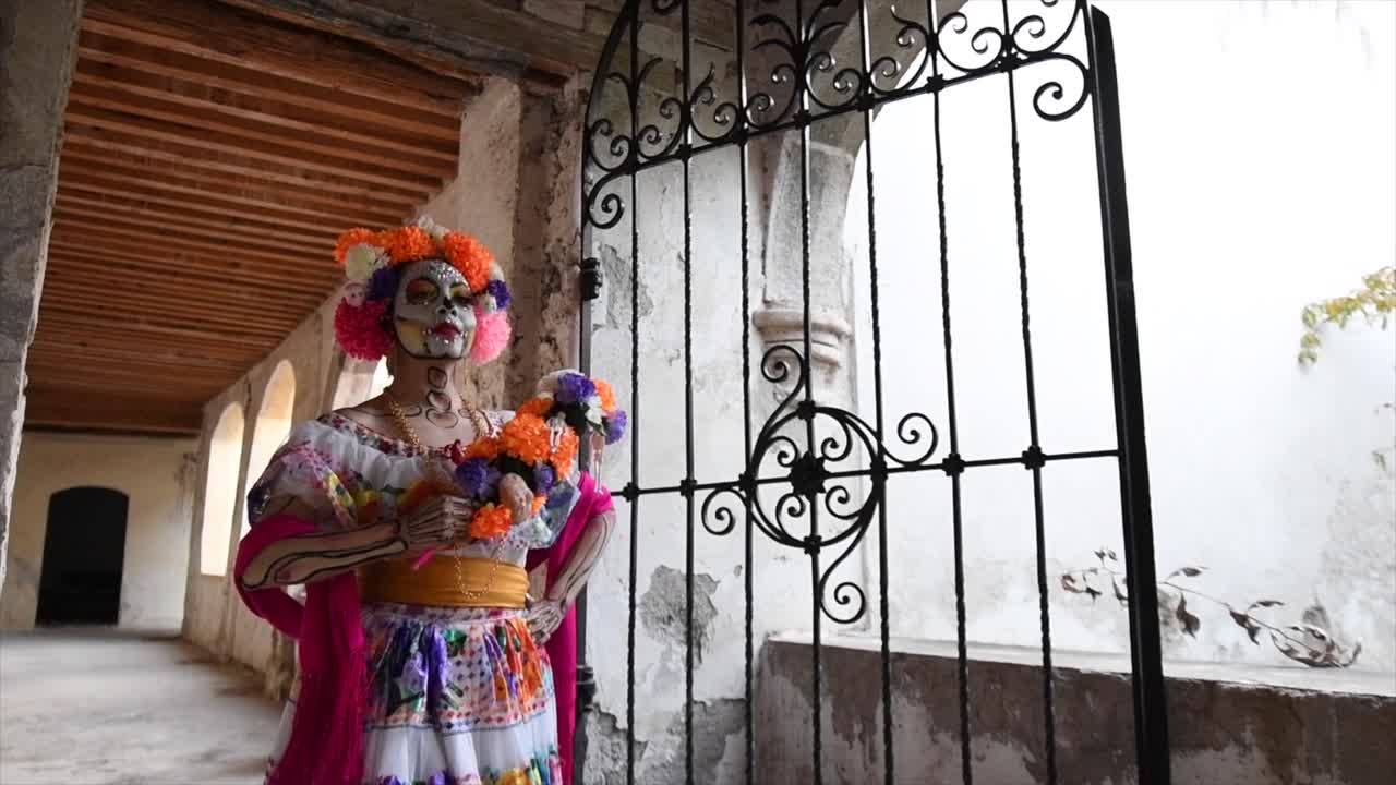 Donna Catrina che cammina in una vecchia casa con fiori in testa