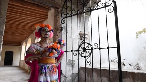 Catrina-Frau,-Die-In-Altes-Haus-Mit-Blumen-Auf-Ihrem-Kopf-Geht