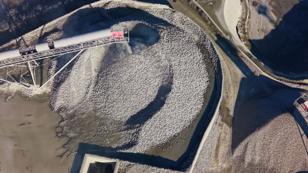 Expansive view of gravel piles at a construction site during a sunny midday, showcasing the intricate patterns and textures formed by natural materials