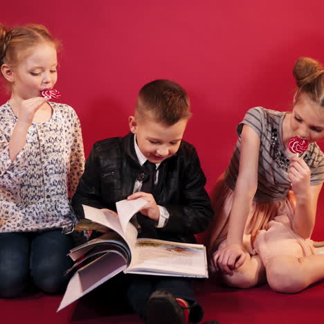 curious children reading book together. happy childhood. studio shooting of children square video