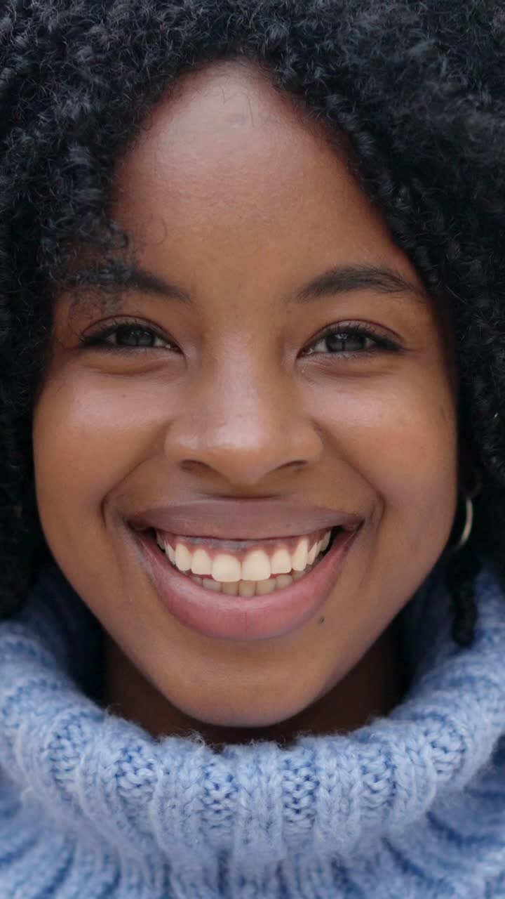 Linda jovem africana sorrindo para a câmera ao ar livre