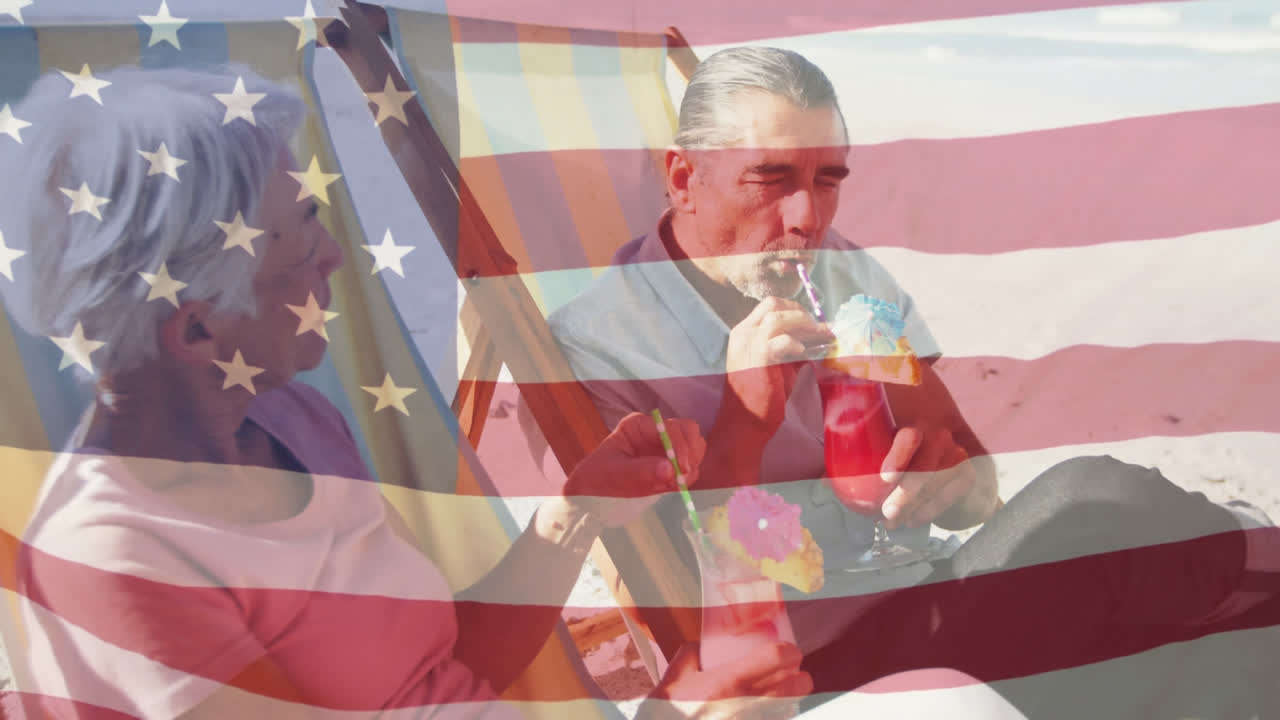 animación de la bandera estadounidense ondeando sobre una pareja de ancianos en sillas de sol tomando bebidas en la playa