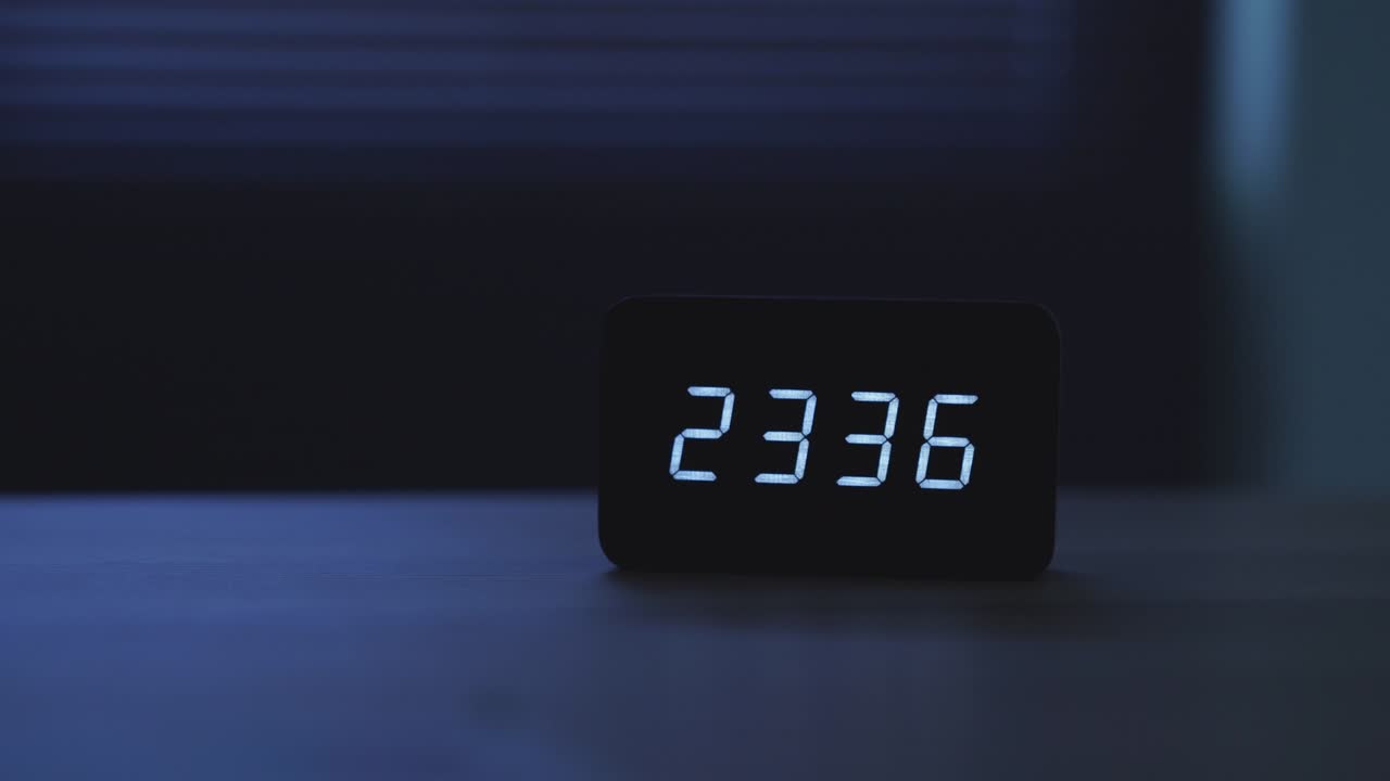 close up of digital alarm clock on the table at night.