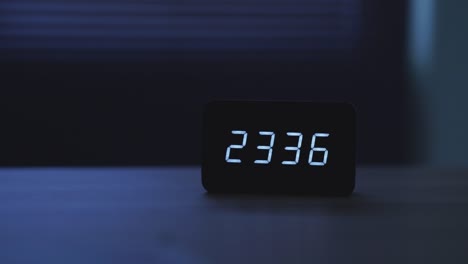 cierre del despertador digital en la mesa por la noche.