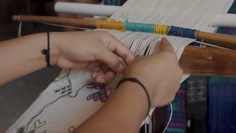 una mujer maya tejiendo textiles tradicionales - de cerca