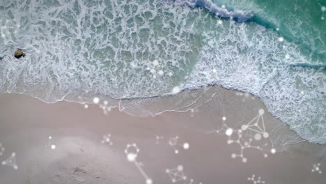 digital composition of molecular structures floating against aerial view of the beach