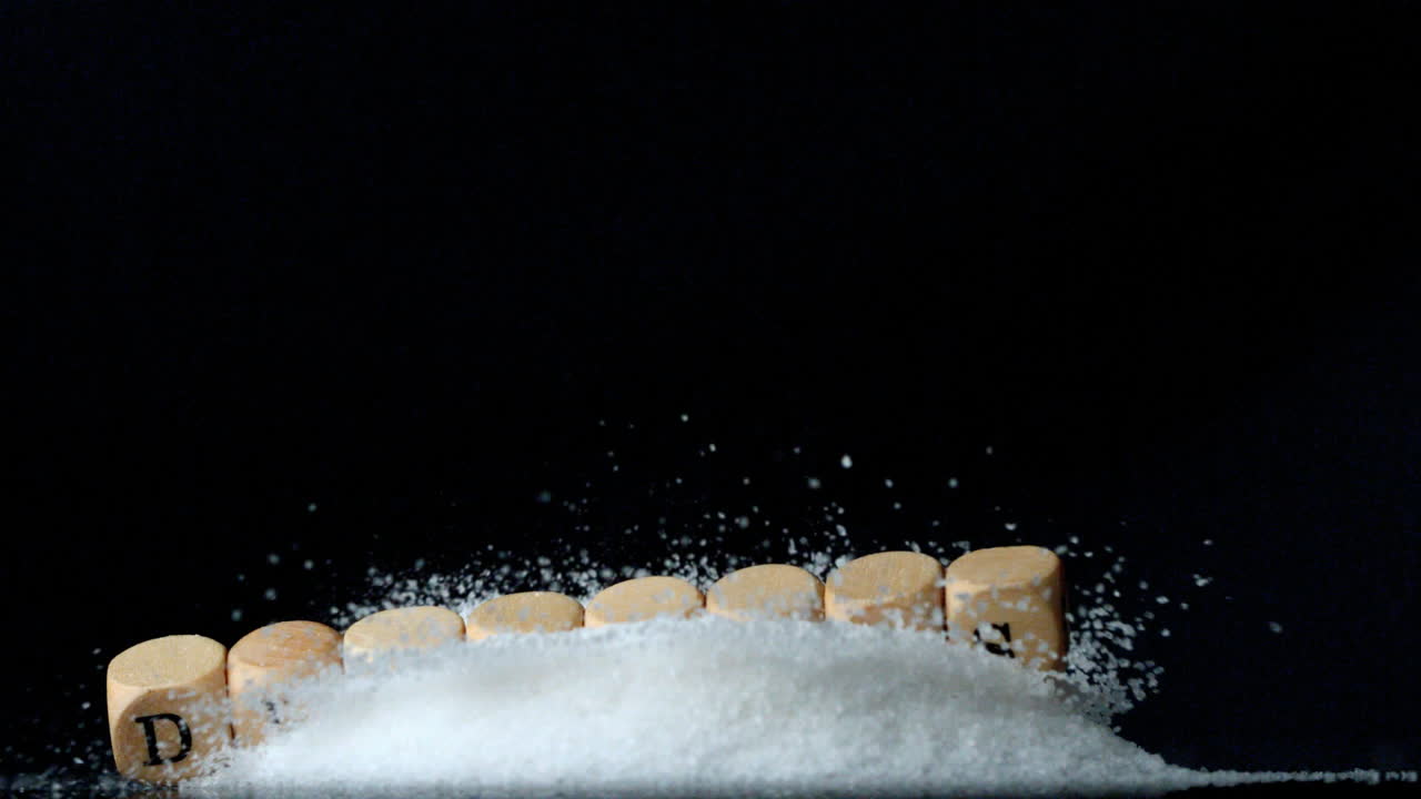 los dados deletreando la diabetes cayendo sobre una pila de azúcar