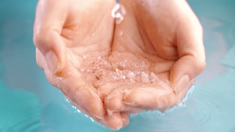 clean drinking water flows in the palms of the woman hands. shot on super slow motion camera 1000 fps.