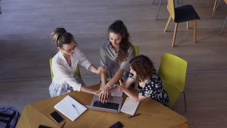 Estudiantes-Haciendo-Un-Trabajo-En-Equipo-En-La-Biblioteca,-Reuniendo-Las-Manos---Vista-De-ángulo-Alto