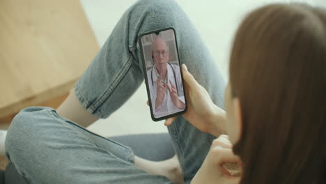 mujer usando una aplicación médica en un teléfono inteligente consultando con un médico árabe musulmán con hijab a través de videoconferencia. mujer usando un chat en línea para hablar con un terapeuta familiar y la pandemia de coronavirus.