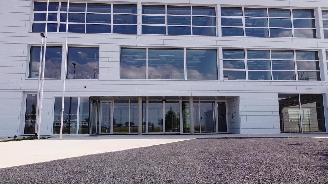 un gran edificio blanco adornado con innumerables ventanas brilla bajo el sol, exudando elegancia y sofisticación