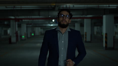 businessman walking in a dark parking garage at night