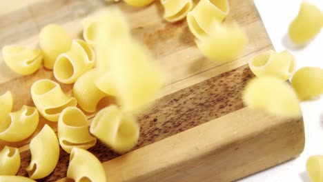 pasta cruda que cae en la tabla de cortar