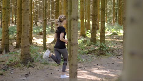 young, fit woman doing short sprints on a park trail