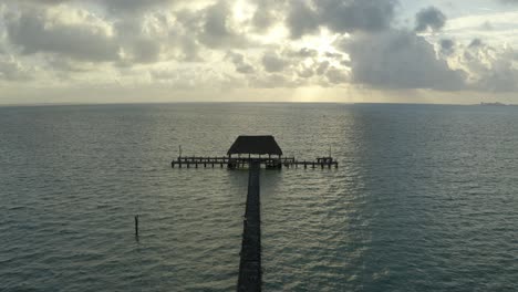 Aerial-drone-forward-moving-shot-of-wooden-pier-on-sea-water-in-Mexico,-North-America