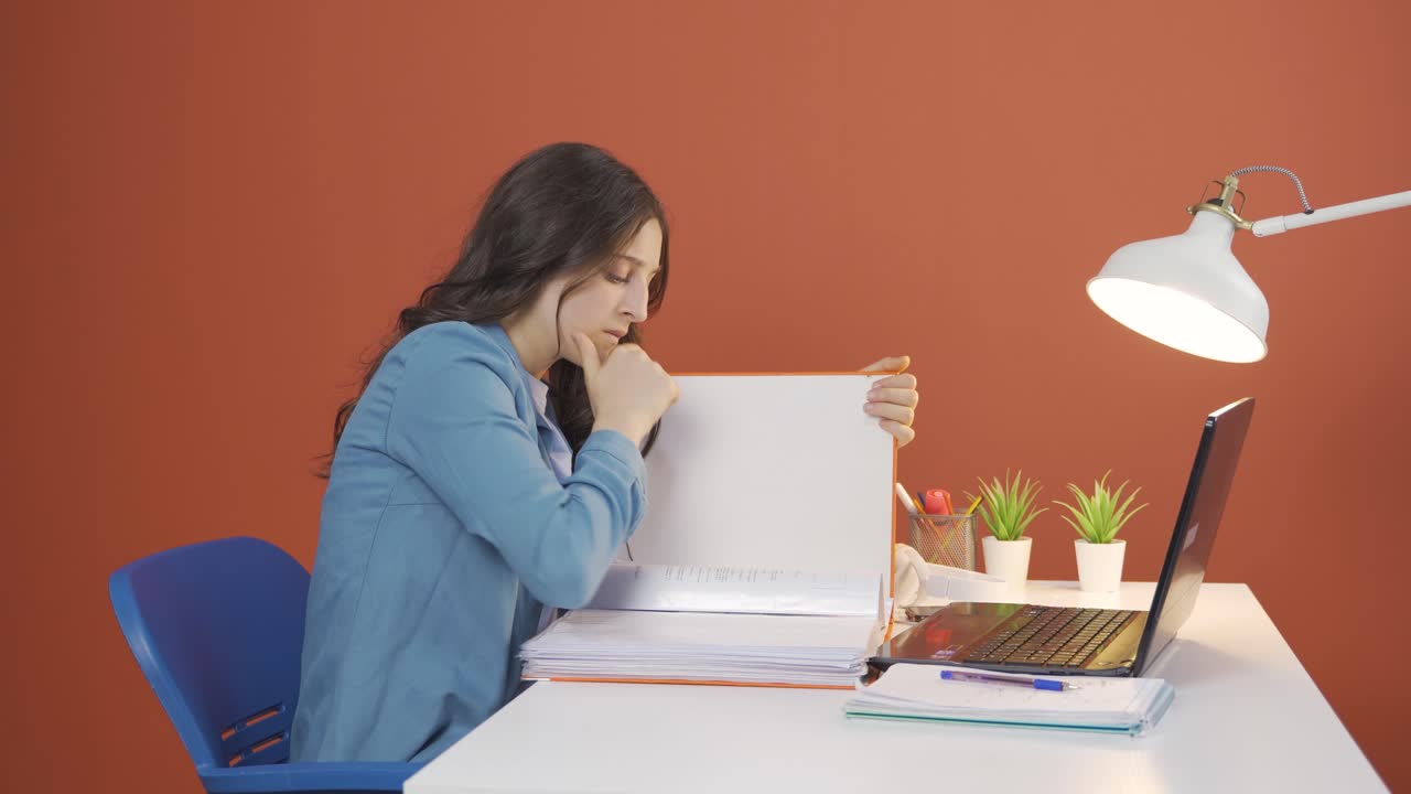 서류를 보는 젊은 여성은 사려 깊습니다.