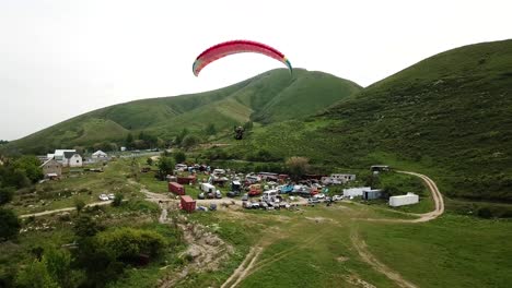 paragliding in the mountains. green fields, hills