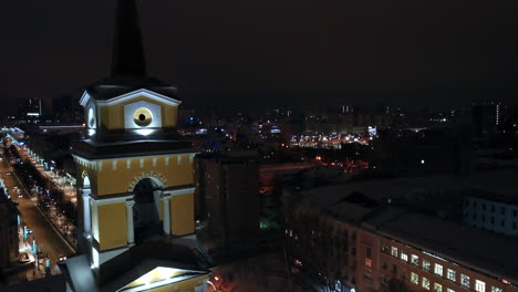 vista nocturna de una iglesia en una ciudad nevada