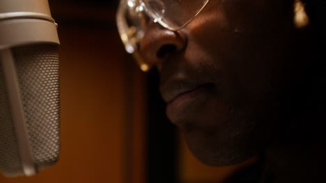 man singing into microphone in recording studio