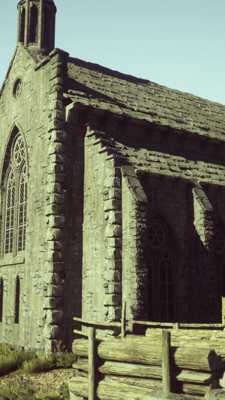 Güneşli bir günde yemyeşil bitki örtüsünün arasında yükselen antik taş kilise.