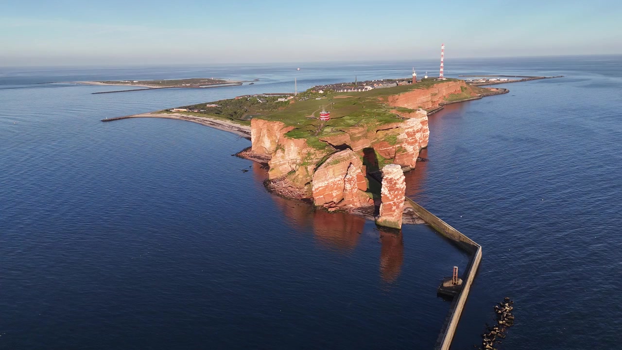 Forhøjet cirkulært droneperspektiv af Helgolands klipper, øen Düne og glødende aftenklipper