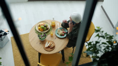 senior woman having lunch and talking on phone