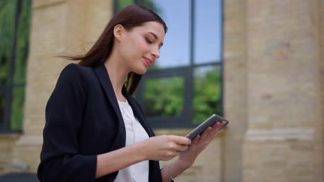 Business-lady-using-tablet-outdoors.-Smiling-woman-greeting-colleague-on-street.