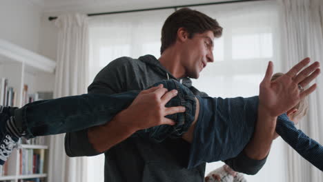 happy father holding little boy pretending to fly playing fun game with dad at home 4k