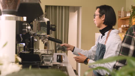 waiter cleaning coffee machine with a cloth