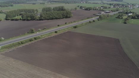 drone aerial view above british a580 east lancs highway in rural agricultural countryside wide orbit left